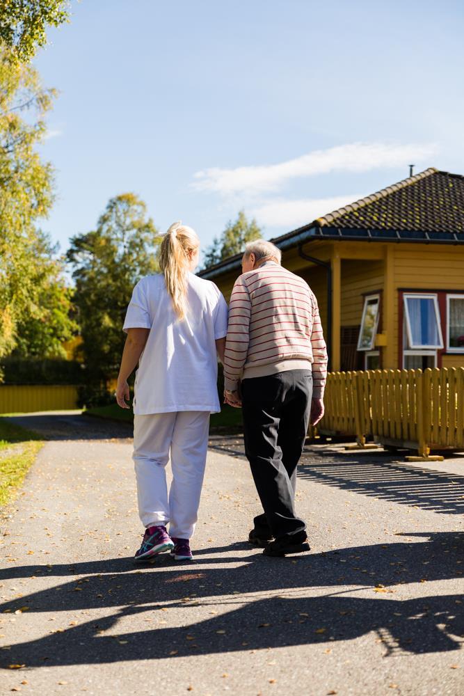 Pleier som går tur ute med pasient om sommeren  - Klikk for stort bilde